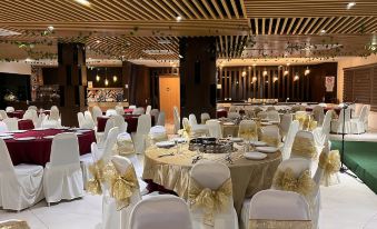 a large banquet hall with multiple round tables and chairs set up for a formal event at D Arc Hotel