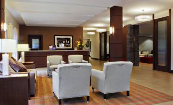 a hotel lobby with two chairs placed next to each other , one on the left and the other on the right at Four Points by Sheraton Winnipeg South