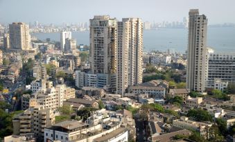 a city skyline with multiple tall buildings , some of which have green spaces in them at Garden Hotel