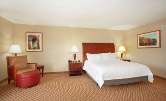 a large bed with white linens is in a hotel room with two lamps on the nightstands at Hilton Garden Inn Casper