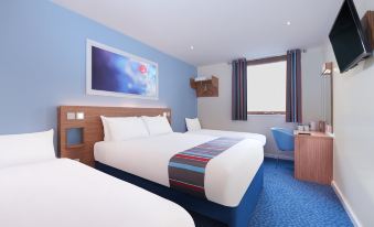 a hotel room with two beds , one on the left and one on the right side of the room at Travelodge Norwich Central Riverside