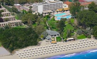 aerial view of a resort on the beach , with a large building and a swimming pool visible at Olympian Bay Grand Resort