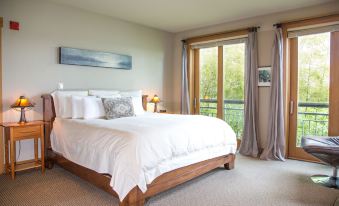 a large bedroom with a king - sized bed , white linens , and a view of the outdoors at The Inn at Langley