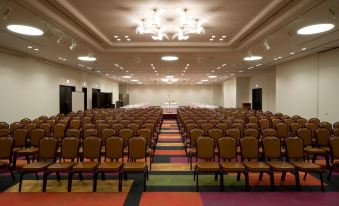a large conference room with rows of chairs arranged in a semicircle , and a podium at the front of the room at Hotel Kanazawa