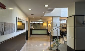 a modern , well - lit hotel lobby with a reception desk and a staircase leading to the second floor at Hotel Kristall