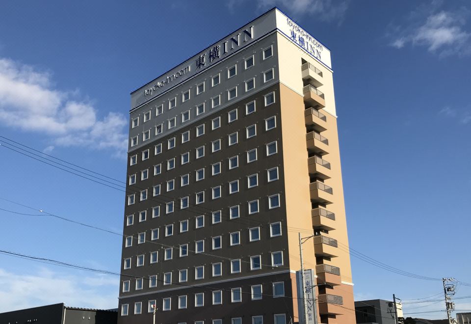 "a tall building with a brown and tan facade , topped with a blue sign that reads "" mgm "" in the top left corner" at Toyoko Inn Meitetsu Chiryu Ekimae