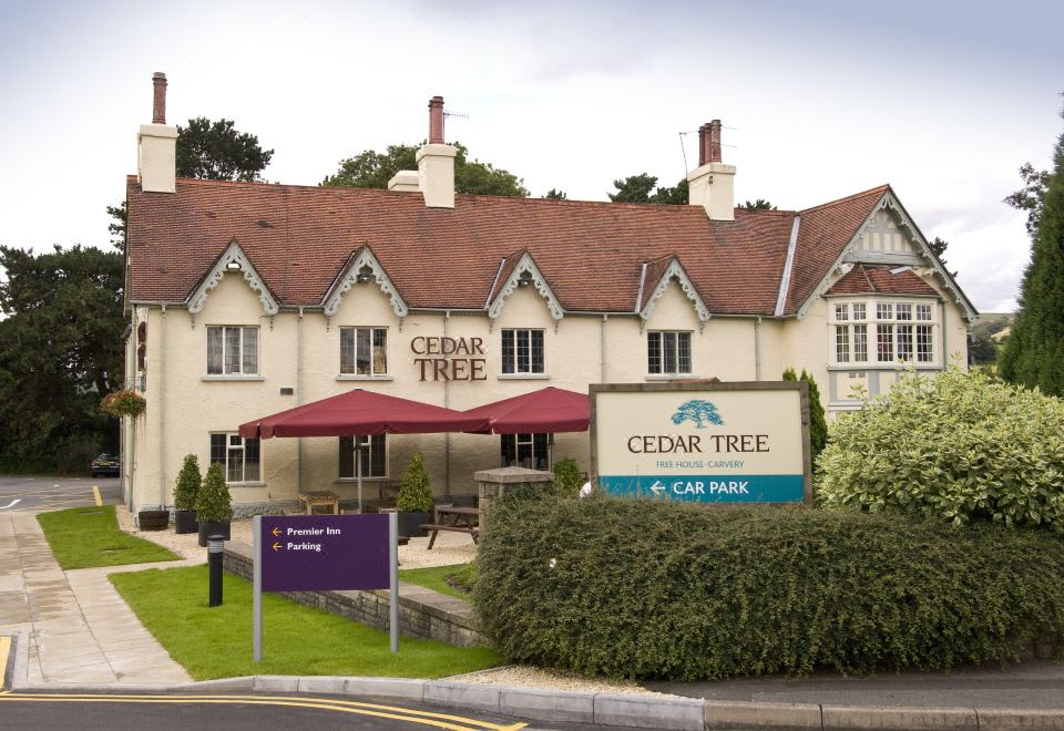 "a large , white building with a sign that reads "" cedar tree hotel "" in front of it" at Premier Inn Caerphilly (Corbetts Lane)
