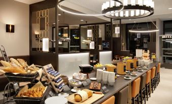 a restaurant buffet with a variety of food options , including sandwiches , salads , and other dishes at Hilton Garden Inn Zurich Limmattal