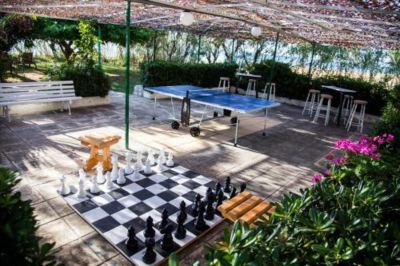 a large outdoor table with chess boards and chess pieces set up under a green canopy at Hotel Summery