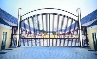 a large open gate with a wrought iron design , leading to a blue and white tiled patio at Pudis Ville