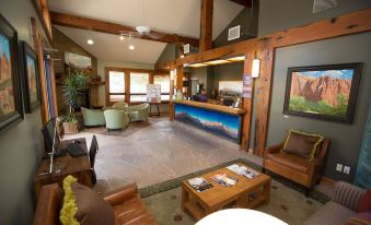 a hotel lobby with a reception desk , couches , and chairs arranged in a comfortable seating area at Desert Pearl Inn