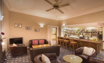 a well - decorated living room with multiple couches , chairs , and tables arranged for a cozy atmosphere at Best Western New Holmwood Hotel