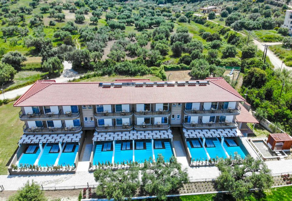 aerial view of a hotel surrounded by green trees , with multiple swimming pools visible in the courtyard at Royal Hotel and Suites