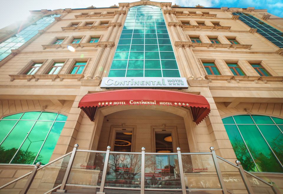 "a large building with a red awning and a sign that says "" the continental hotel ""." at Continental Hotel