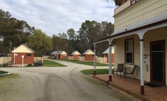 "a small town with a dirt road leading to a row of small houses , some of which have a sign that reads "" picton ""." at Deniliquin Pioneer Tourist Park