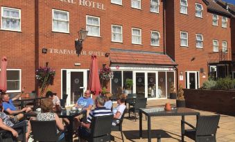a group of people sitting outside a royal hotel , enjoying their time in the sun at The Royal Hotel