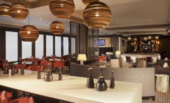 a modern restaurant with wooden pendants hanging from the ceiling , creating a warm and inviting atmosphere at Hyatt Regency Long Island