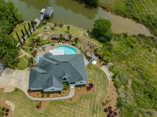 Beautiful Waterfront Home with abundant outdoor seating, pool, hot tub, grill