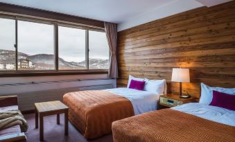a hotel room with two beds , one on the left and one on the right side of the room at Okushiga Kogen Hotel