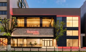"a modern building with a red sign that says "" ramada by wyndham "" is shown on a street" at Ramada by Wyndham Ramnicu Valcea