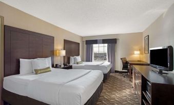 a hotel room with two beds , a desk , and a window , all set against a beige background at La Quinta Inn & Suites by Wyndham Springfield MA