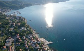 a beautiful coastal town with clear blue waters and white houses , as well as boats floating on the water at Hotel Perla