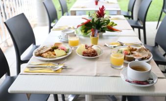 a dining table set with a variety of breakfast items , including plates , bowls , cups , and utensils at Hotel Saint - Georges