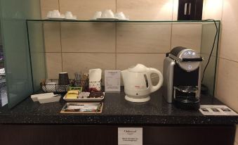 In the middle room, there is a counter with coffee and other items on it, located next to an espresso machine at Oakwood Apartments Roppongi Central
