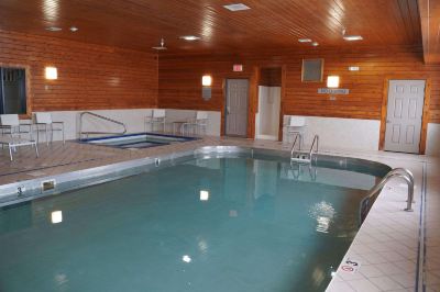 a large indoor swimming pool with a wooden interior and two swimming pools lined with stairs at Country Inn & Suites by Radisson, Watertown, SD