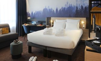 a large bed with white linens and a wooden headboard is in a room with a forest mural on the wall at Novotel Annemasse Centre - Porte de Genève