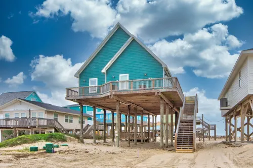 Martinis & Bikinis, a beach front house with toes in the sand drink in the hand.