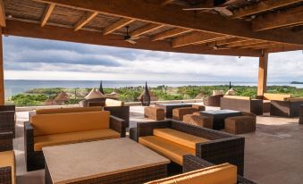 a rooftop patio with several couches and chairs arranged for people to relax and enjoy the view of the ocean at Hotel Las Islas