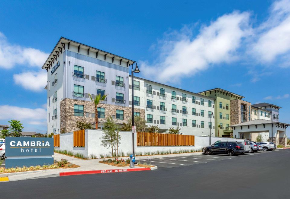 an apartment building surrounded by a parking lot , with cars parked in front of it at Hotel Centro Sonoma Wine Country, Tapestry by Hilton