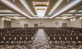 a large , empty conference room with rows of brown chairs and a chandelier hanging from the ceiling at Grand Hyatt Vail