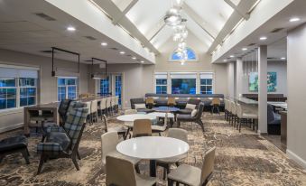 a large , modern dining area with multiple tables and chairs arranged in an open space at Residence Inn Boston Westford