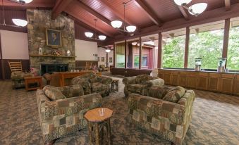 a cozy living room with multiple couches , chairs , and a fireplace , creating a warm and inviting atmosphere at Carter Caves State Resort Park