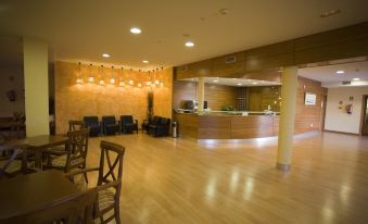 a large , well - lit hotel lobby with wooden floors and a bar area , providing a comfortable environment for guests at La Canada