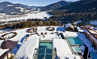 a snow - covered ski resort with a large group of people enjoying the winter sports activities at Alpin Panorama Hotel Hubertus