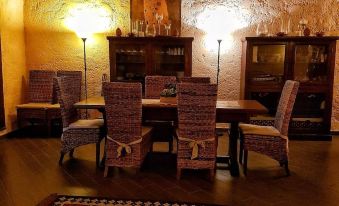 a dining room with a wooden table , chairs , and a rug on the floor , illuminated by two lamps at CasAda