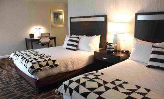 a hotel room with two beds , each covered in black and white checkered comforters , and lamps on nightstands at Gold Country Casino Resort