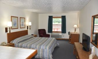 a hotel room with two beds , one on the left and one on the right side of the room at Luxor Inn & Suites, a Travelodge by Wyndham