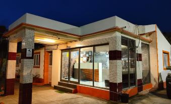 a small store with a glass door , located in a residential area at night , and illuminated by street lights at Hotel Palms