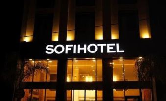 the exterior of a sofi hotel lit up at night , with the hotel 's name displayed prominently at Sofi Hotel
