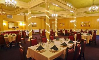 a large dining room filled with tables and chairs , ready for guests to enjoy a meal at Hotel Coolidge