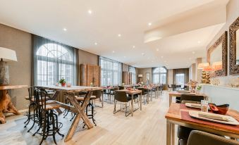 a large , modern dining room with wooden tables and chairs arranged for a group of people to enjoy a meal together at Hotel Acropolis