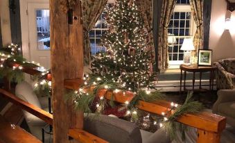 a christmas tree in the corner of a room with wooden beams and a christmas tree in the background at Dowds Country Inn