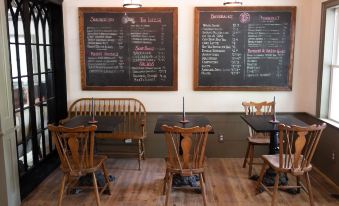 a dining room with wooden chairs and tables , along with a blackboard on the wall at Stonehill's Farmhouse