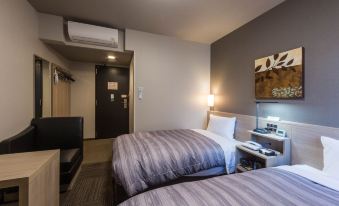 a hotel room with two beds , one on the left and one on the right side of the room at Hotel Route-Inn Fuji Chuo Koen Higashi