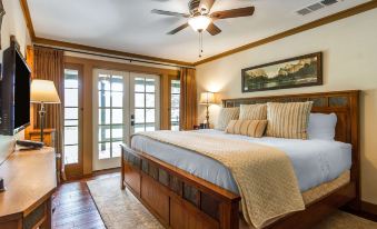 a cozy bedroom with wooden furniture , a large bed , and a ceiling fan , along with a view of the outdoors at Sierra Sky Ranch, Ascend Hotel Collection