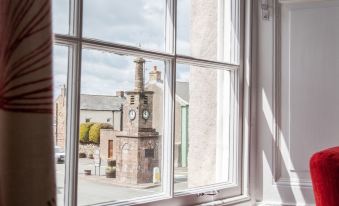 a window with a view of a cityscape , including a clock tower and another building at The Inn at Brough